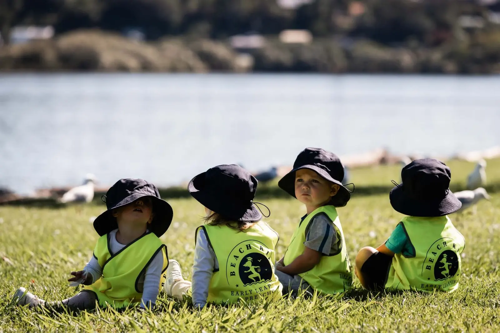 A group of Beach Kids children sitting together on the riverbank