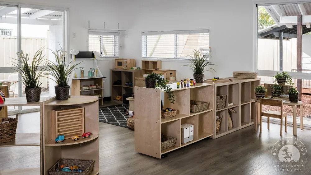 A wide view of a Beach Kids classroom with timber shelving and plants